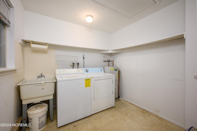 laundry area featuring electric water heater, sink, and washing machine and dryer