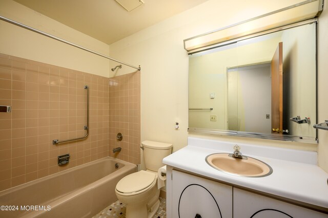 full bathroom featuring vanity, toilet, tiled shower / bath combo, and tile patterned flooring