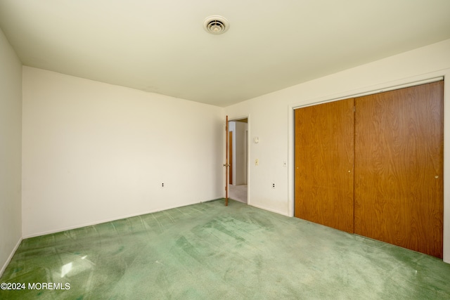 unfurnished bedroom featuring carpet flooring and a closet