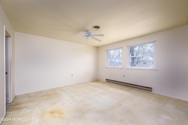 carpeted empty room featuring a baseboard heating unit and ceiling fan