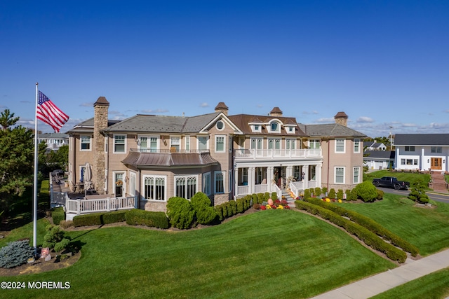 view of front of house with a porch, a front lawn, and a balcony