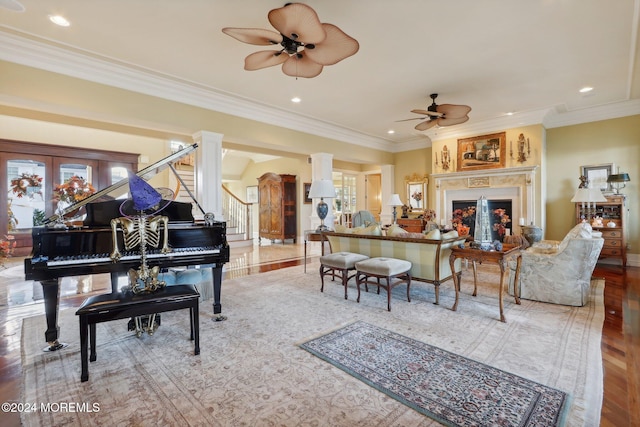 living room featuring crown molding, ornate columns, wood-type flooring, and ceiling fan