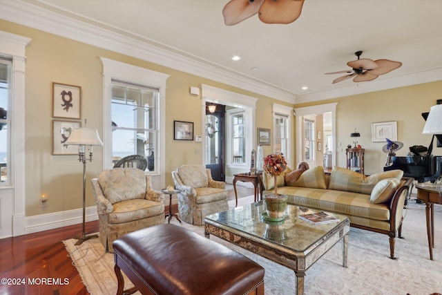 living room featuring ornamental molding, wood-type flooring, and ceiling fan