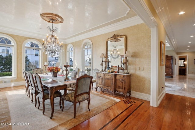 dining area featuring ornamental molding, an inviting chandelier, and light wood-type flooring