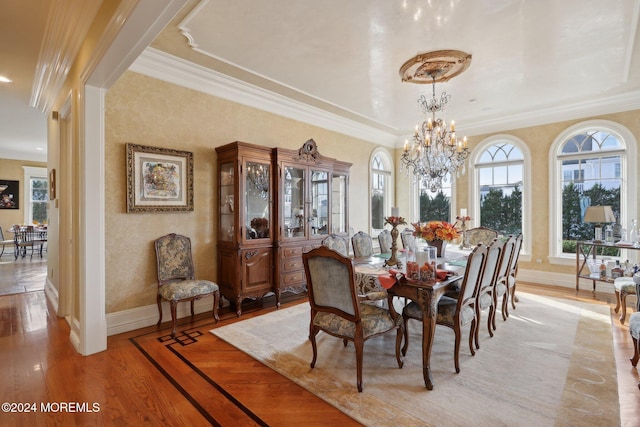 dining room with crown molding, a notable chandelier, and light hardwood / wood-style flooring