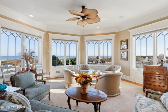 living room with a wealth of natural light, crown molding, and ceiling fan