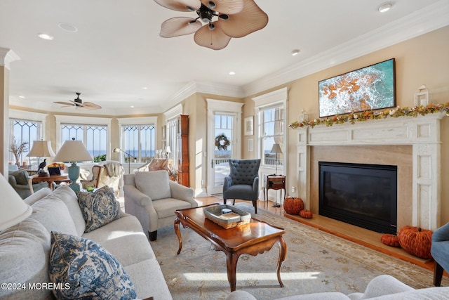 living room with ornamental molding, light wood-type flooring, and ceiling fan