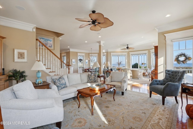 living room featuring ceiling fan, a healthy amount of sunlight, ornamental molding, and light hardwood / wood-style flooring