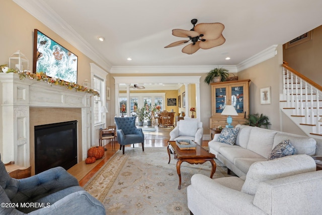 living room with ornamental molding, light wood-type flooring, and ceiling fan