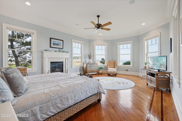 bedroom with ornamental molding, hardwood / wood-style flooring, and ceiling fan