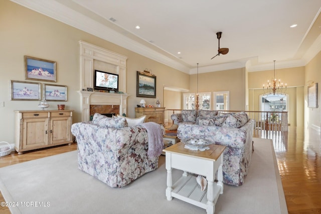 living room featuring ornamental molding, light hardwood / wood-style flooring, and a chandelier