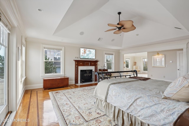 bedroom with light hardwood / wood-style floors, crown molding, multiple windows, and ceiling fan