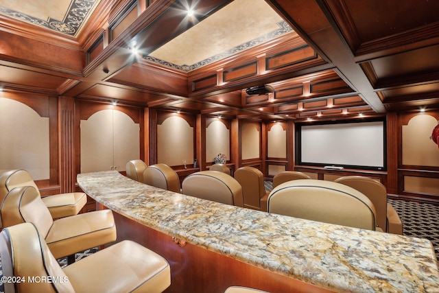 carpeted cinema with beamed ceiling, coffered ceiling, and crown molding