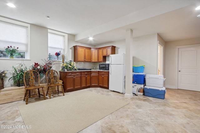 1805 Ocean Ave, Spring Lake, NJ 07762 - kitchen with freestanding refrigerator, black microwave, brown cabinetry, light countertops, and recessed lighting