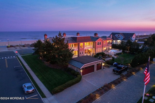 aerial view at dusk featuring a water view