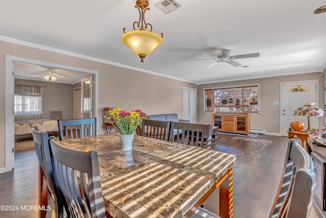 dining area featuring crown molding, dark wood-type flooring, and ceiling fan