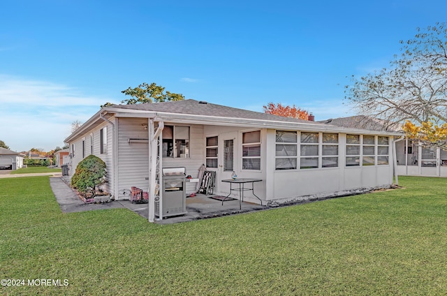 rear view of property featuring a patio and a lawn