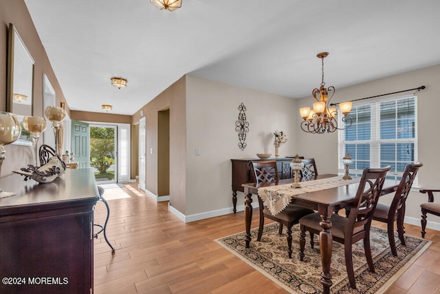 dining room with light hardwood / wood-style floors and an inviting chandelier