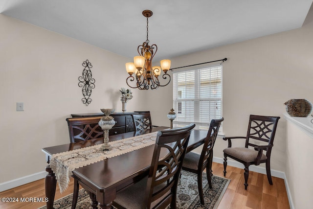 dining room with hardwood / wood-style flooring and a chandelier