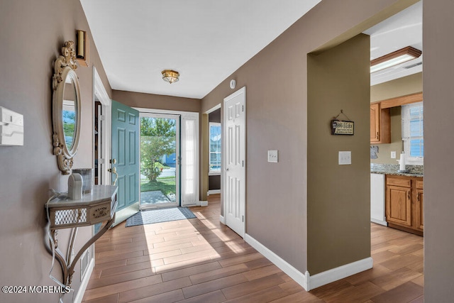 foyer with light hardwood / wood-style flooring and beam ceiling