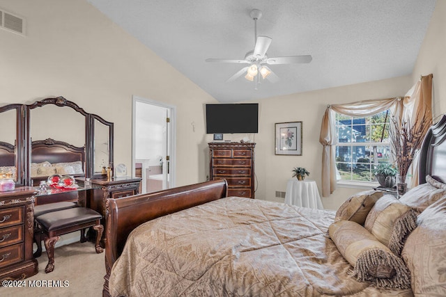 carpeted bedroom featuring ceiling fan, a textured ceiling, vaulted ceiling, and ensuite bathroom