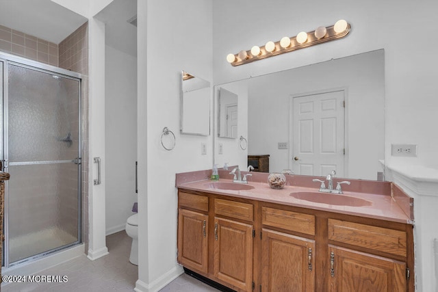 bathroom with vanity, a shower with shower door, toilet, and tile patterned flooring