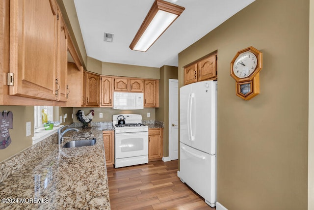 kitchen featuring sink, light hardwood / wood-style flooring, light stone counters, and white appliances