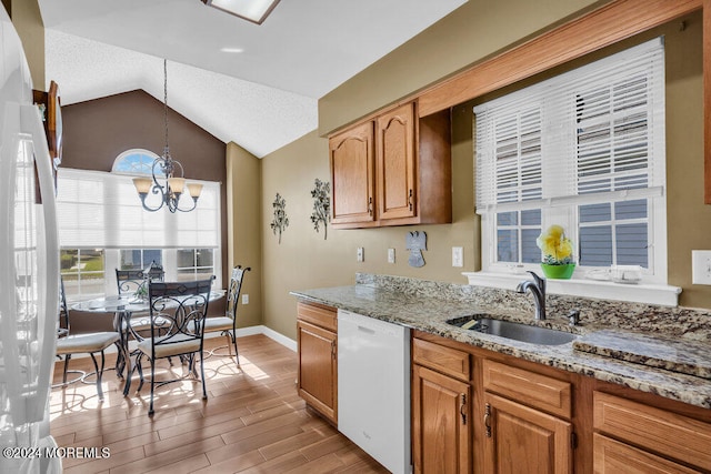 kitchen with white appliances, sink, light wood-type flooring, lofted ceiling, and decorative light fixtures