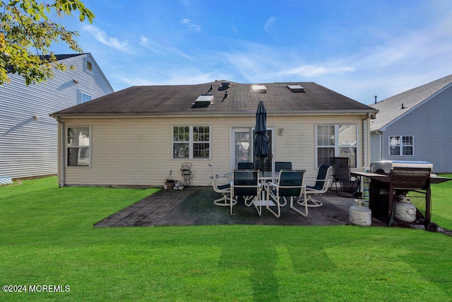 back of property featuring a patio area and a yard