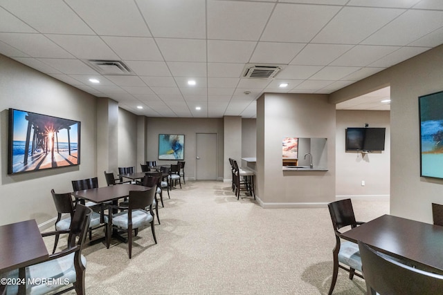 dining room featuring a paneled ceiling and light carpet