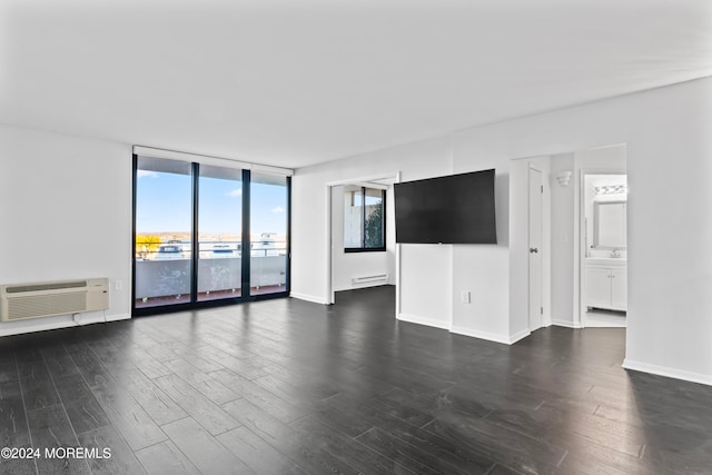 unfurnished room featuring dark wood-type flooring, a baseboard radiator, floor to ceiling windows, and a wall mounted air conditioner