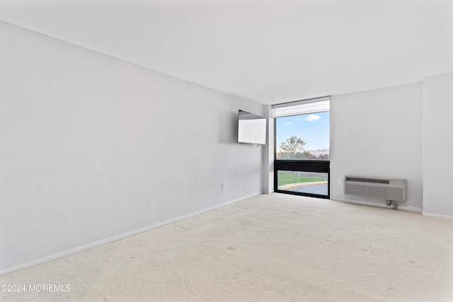 carpeted spare room featuring a wall mounted air conditioner