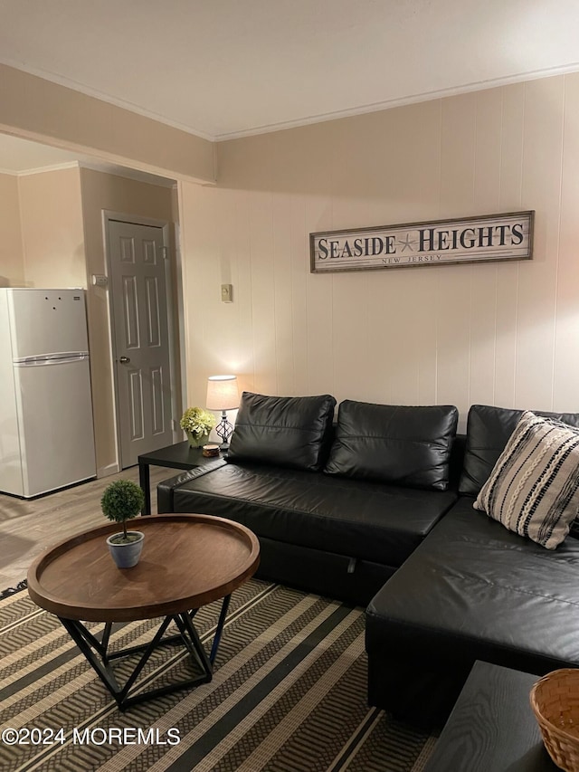 living room featuring crown molding, hardwood / wood-style flooring, and wooden walls