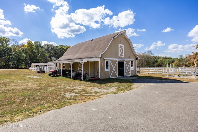 view of front of house with a front lawn and an outbuilding