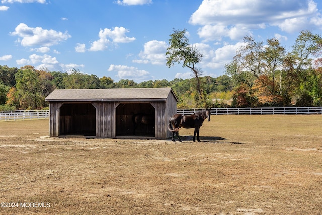 view of horse barn with a rural view