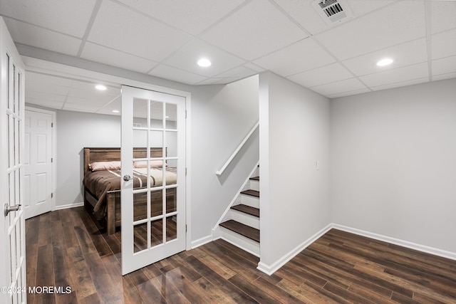 bedroom with a drop ceiling and dark hardwood / wood-style floors