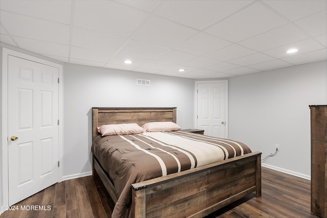 bedroom featuring a paneled ceiling and dark hardwood / wood-style floors