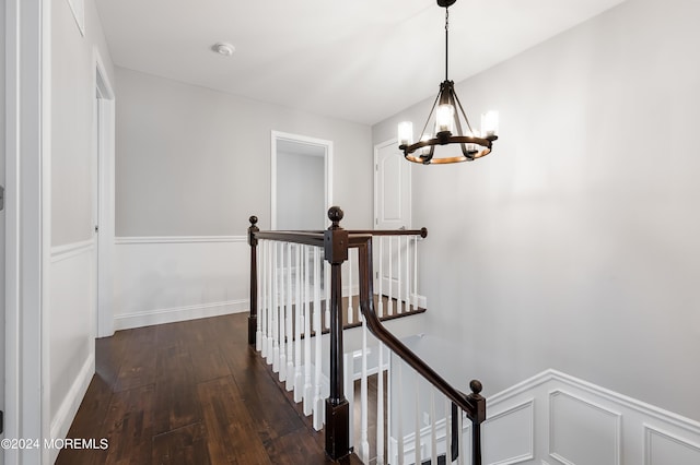 corridor featuring dark wood-type flooring and a chandelier