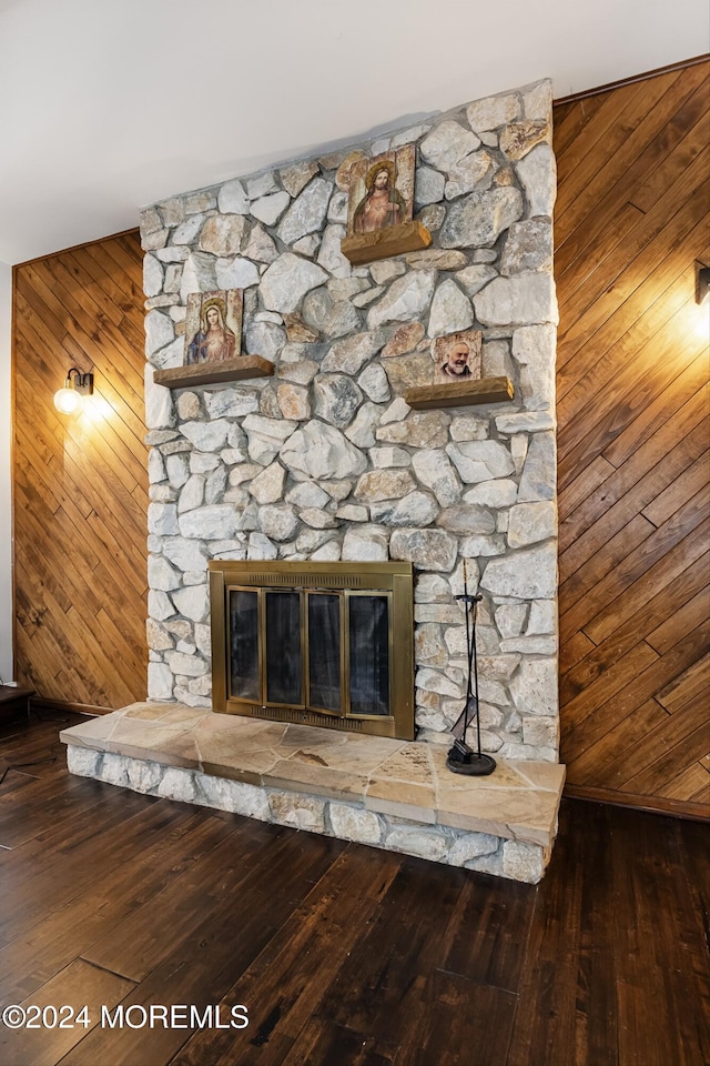 details with hardwood / wood-style floors, wooden walls, and a fireplace