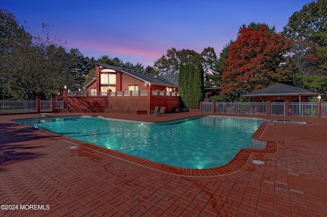 pool at dusk with a patio