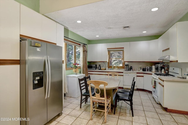 kitchen featuring appliances with stainless steel finishes, a textured ceiling, ventilation hood, and white cabinets