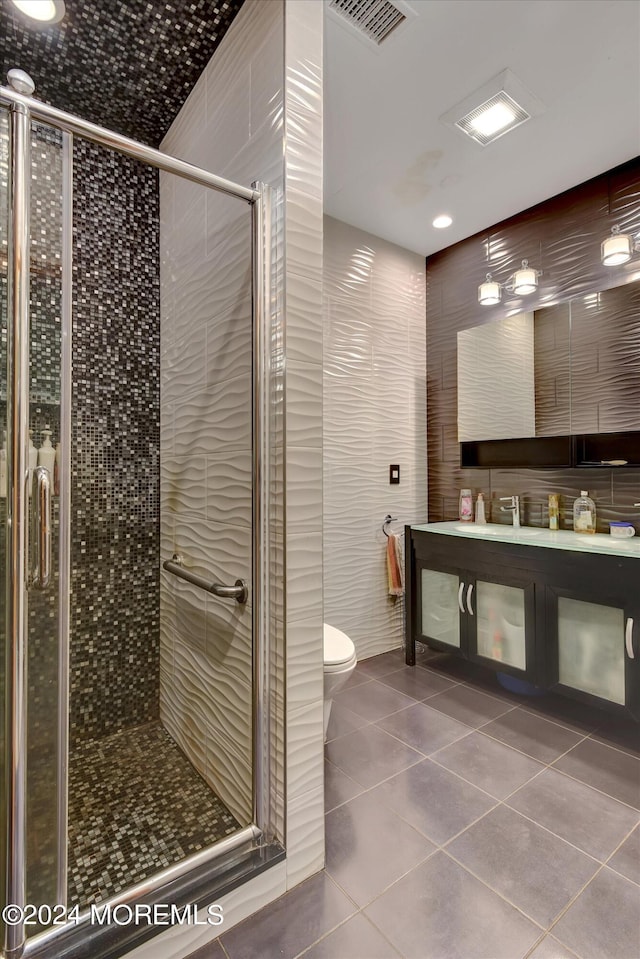 bathroom with toilet, walk in shower, vanity, and tile patterned flooring