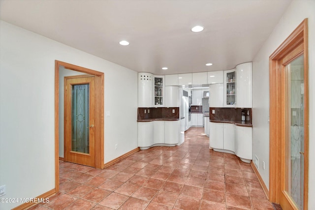 kitchen with white fridge, white cabinets, tasteful backsplash, and light tile patterned flooring