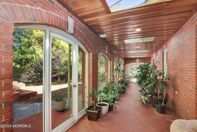 unfurnished sunroom featuring a skylight