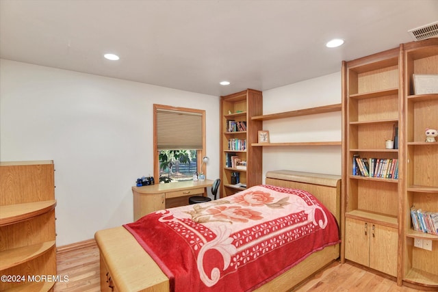 bedroom featuring built in desk and light wood-type flooring