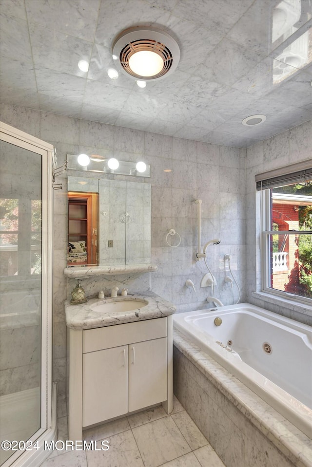 bathroom with tile walls, vanity, and plus walk in shower