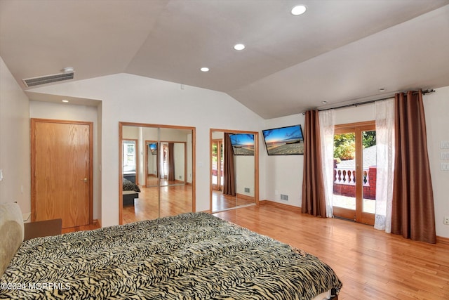 bedroom with wood-type flooring, vaulted ceiling, and access to exterior