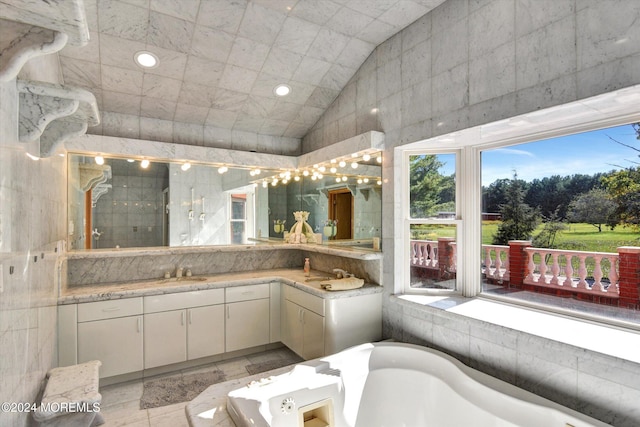 bathroom with vanity, vaulted ceiling, shower with separate bathtub, and tile patterned floors