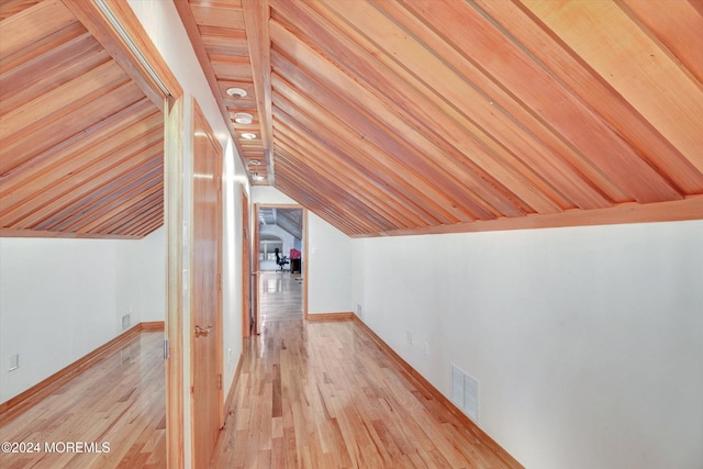 bonus room featuring light wood-type flooring and vaulted ceiling