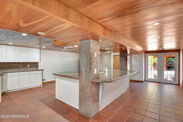 kitchen with french doors, wood ceiling, tile patterned flooring, stone counters, and white cabinetry